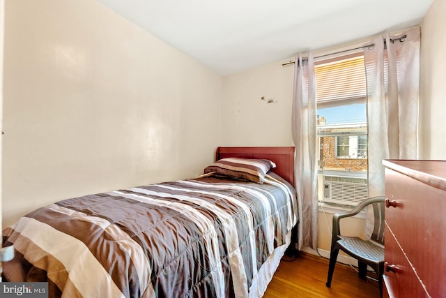 bedroom with cooling unit and wood-type flooring