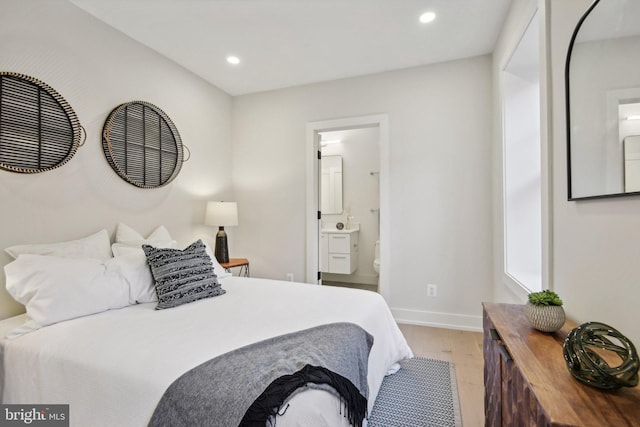 bedroom featuring ensuite bathroom and light hardwood / wood-style floors