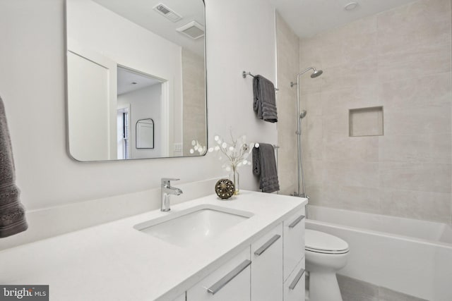 full bathroom with vanity, tiled shower / bath combo, and toilet