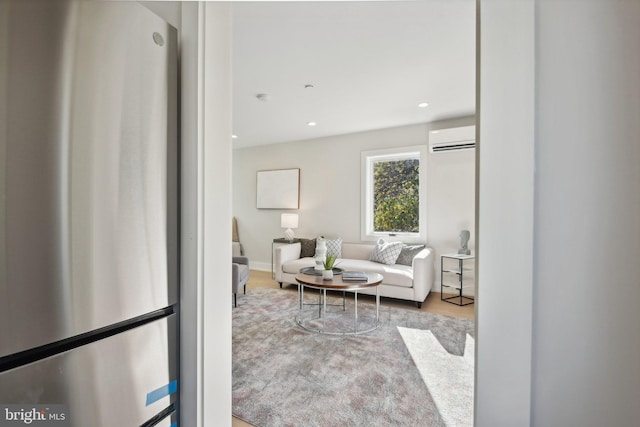 living room featuring a wall unit AC and light hardwood / wood-style flooring