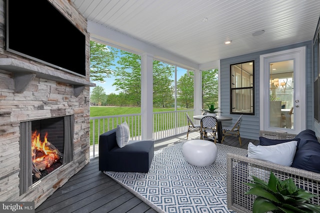 deck with an outdoor stone fireplace