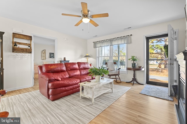 living room with light hardwood / wood-style floors and ceiling fan