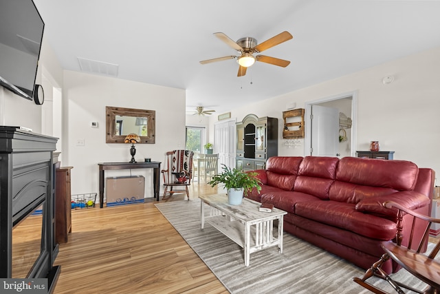 living room featuring light hardwood / wood-style floors and ceiling fan