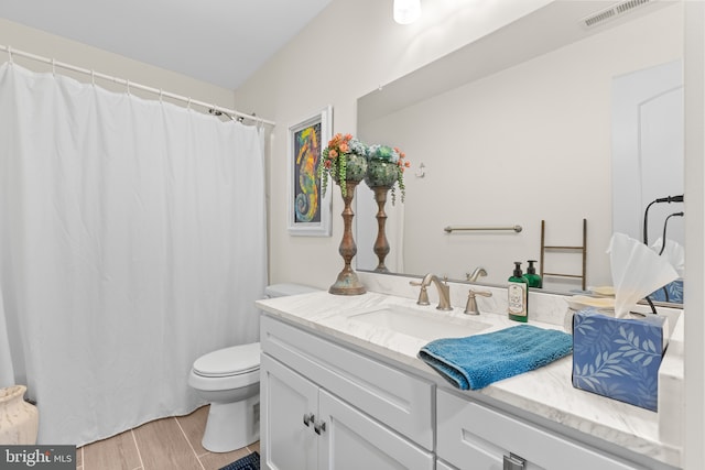 bathroom with hardwood / wood-style floors, vanity, and toilet