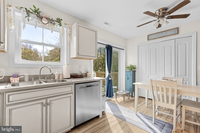 kitchen featuring ceiling fan, light hardwood / wood-style flooring, stainless steel dishwasher, and sink