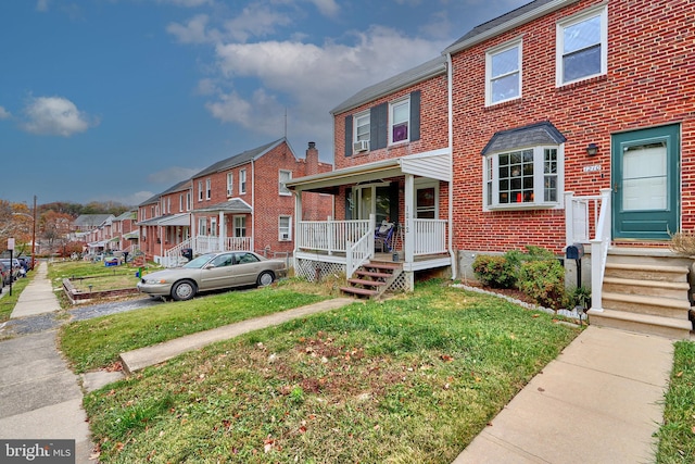 townhome / multi-family property with a porch and a front lawn