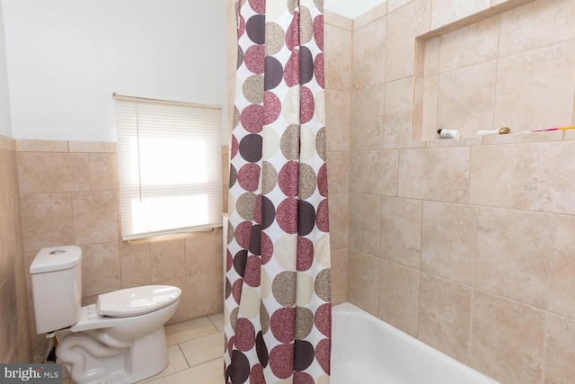 bathroom with toilet, tile patterned flooring, tile walls, and shower / bath combo