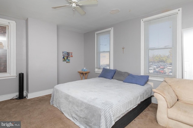 bedroom with light carpet, ceiling fan, and multiple windows