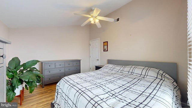 bedroom featuring ceiling fan, light hardwood / wood-style flooring, and lofted ceiling