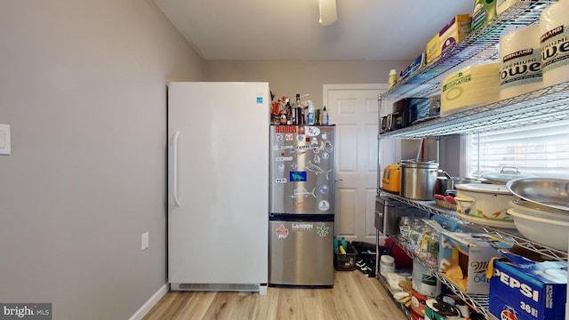 kitchen with stainless steel fridge, white fridge, and light hardwood / wood-style floors