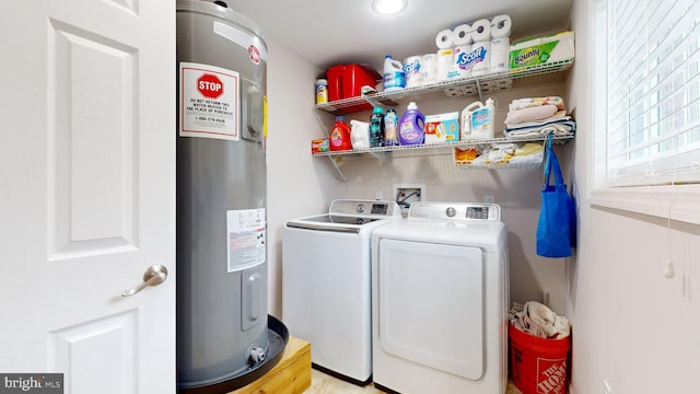 clothes washing area with electric water heater, light hardwood / wood-style flooring, and washer and dryer