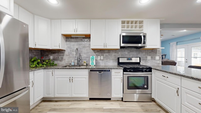 kitchen featuring white cabinets, appliances with stainless steel finishes, stone counters, and sink