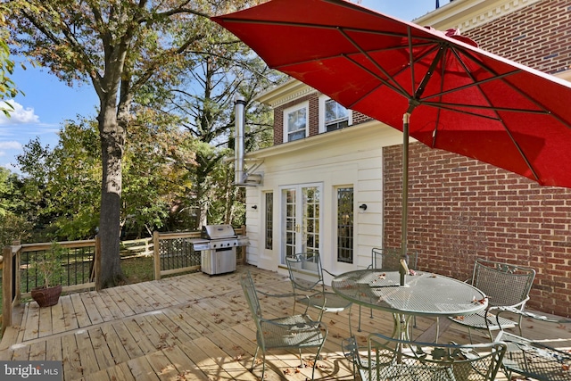 deck featuring outdoor dining area and grilling area