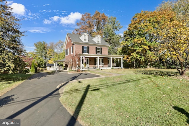 view of front of property with covered porch and a front yard