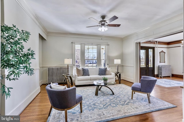 living area with a wealth of natural light, radiator heating unit, and wood finished floors