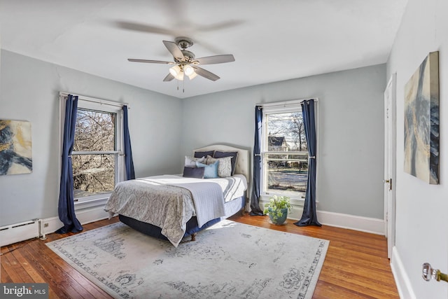 bedroom featuring ceiling fan, wood finished floors, and baseboards