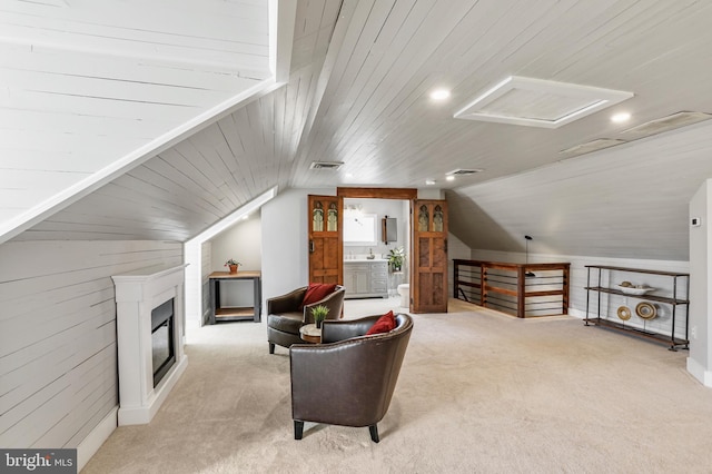 living area featuring visible vents, light carpet, an upstairs landing, and attic access