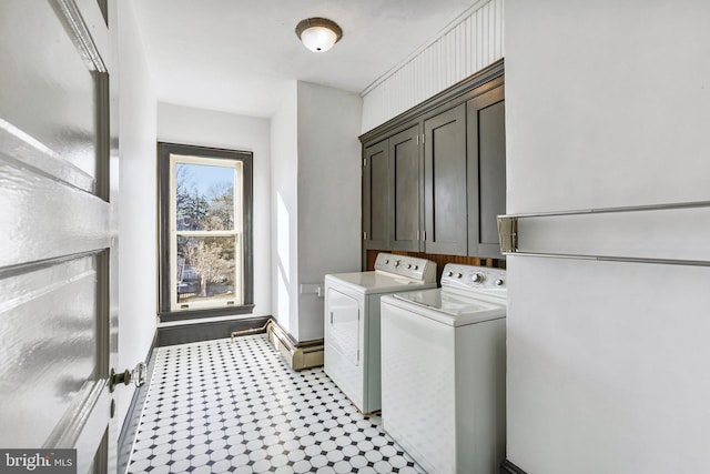 clothes washing area with a baseboard radiator, independent washer and dryer, cabinet space, and baseboards