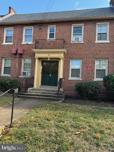187 35th St NE, Washington, DC 20019 - view of front facade featuring brick siding, a front lawn, and a shingled roof
