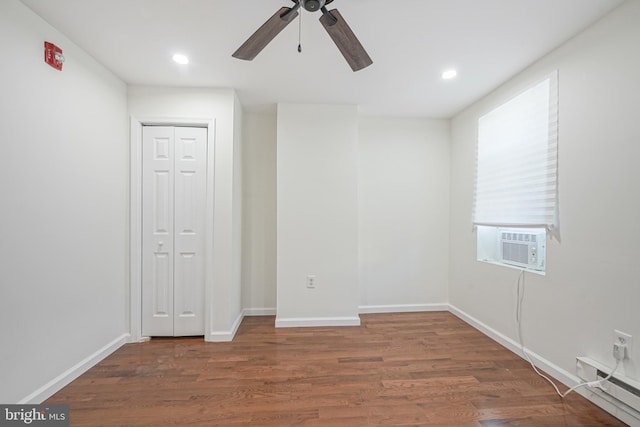 spare room with ceiling fan, dark hardwood / wood-style flooring, cooling unit, and a baseboard heating unit