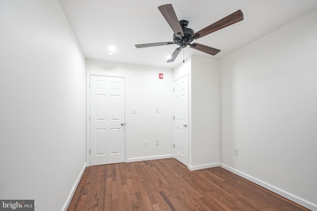 empty room with ceiling fan and dark hardwood / wood-style flooring