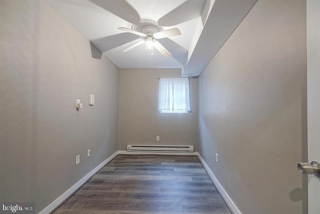 empty room featuring vaulted ceiling, ceiling fan, dark hardwood / wood-style floors, and a baseboard heating unit