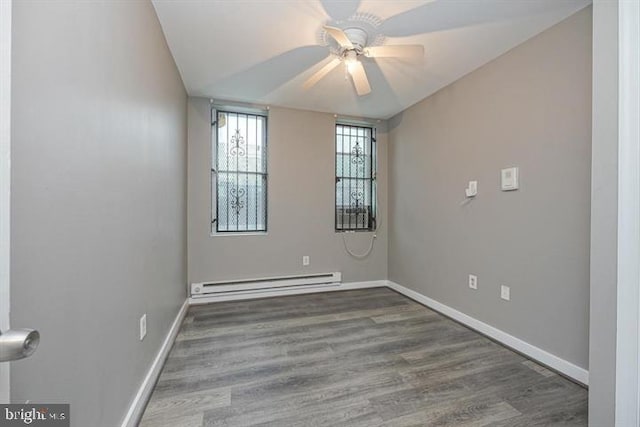 spare room featuring hardwood / wood-style floors, vaulted ceiling, ceiling fan, and a baseboard heating unit