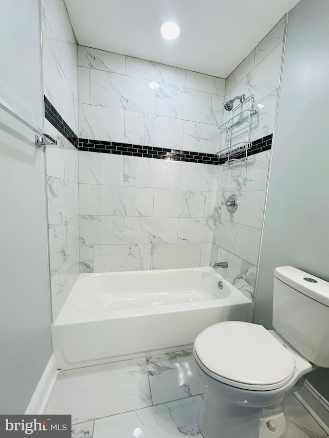 bathroom with tiled shower / bath combo and toilet