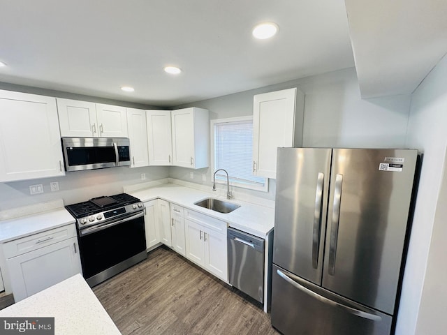 kitchen with white cabinets, appliances with stainless steel finishes, dark wood-type flooring, and sink