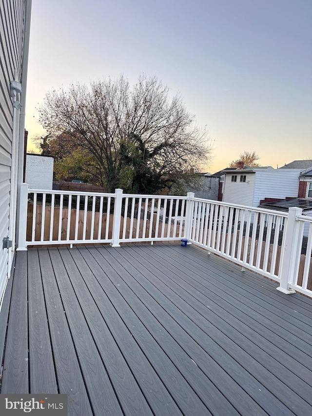 deck at dusk featuring a storage unit