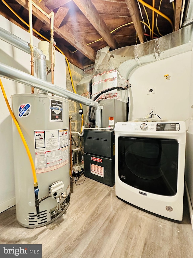 washroom with washer / clothes dryer, water heater, and hardwood / wood-style floors