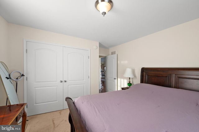 bedroom featuring light carpet and a closet