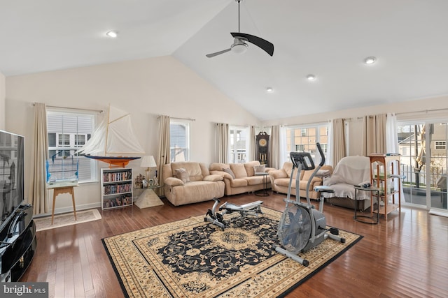 living room featuring dark hardwood / wood-style flooring, high vaulted ceiling, and ceiling fan