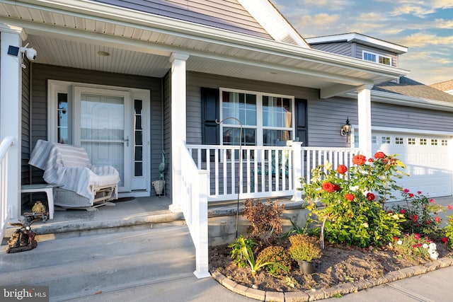 view of exterior entry featuring a porch and a garage