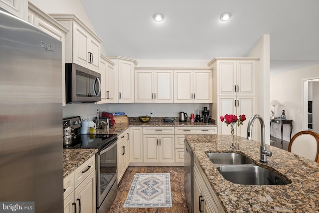 kitchen with dark hardwood / wood-style floors, dark stone countertops, sink, and appliances with stainless steel finishes