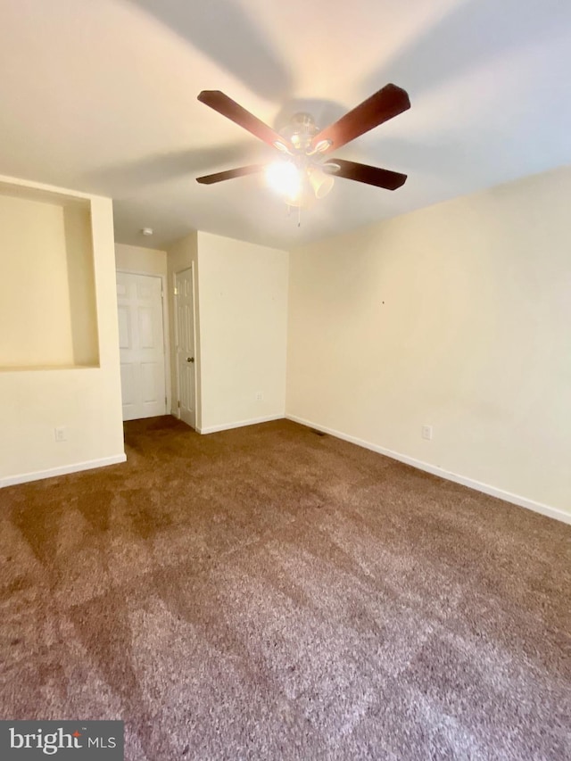 carpeted spare room with ceiling fan