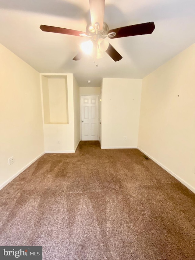 carpeted spare room with ceiling fan