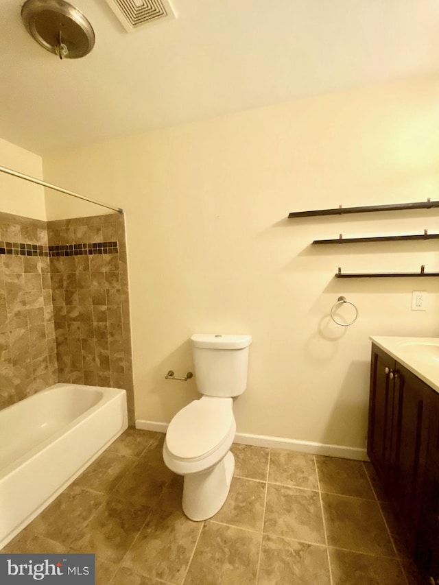 full bathroom featuring vanity, tiled shower / bath, and toilet