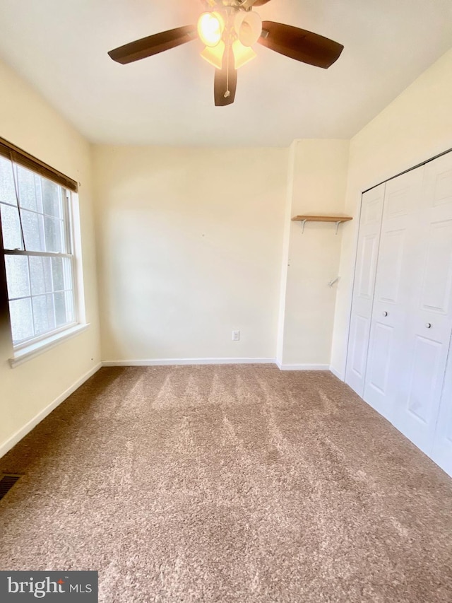 unfurnished bedroom featuring a closet, ceiling fan, and carpet