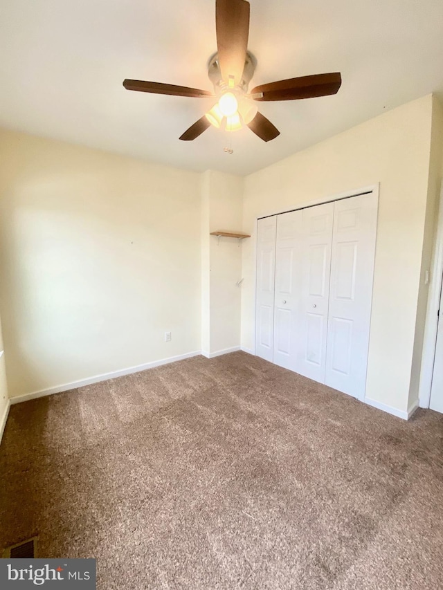 unfurnished bedroom with ceiling fan, a closet, and carpet