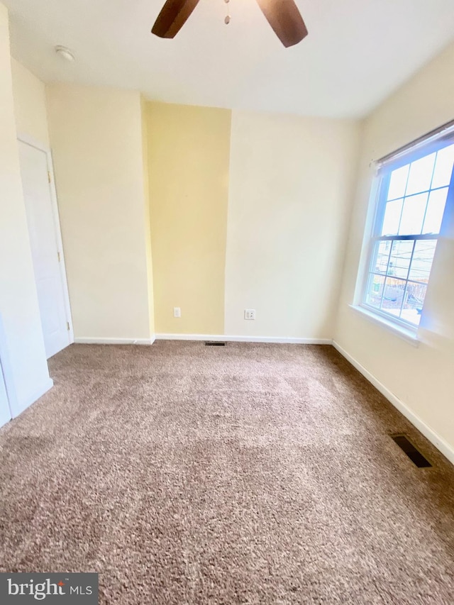 carpeted spare room featuring ceiling fan