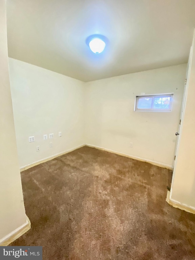 unfurnished room with dark carpet