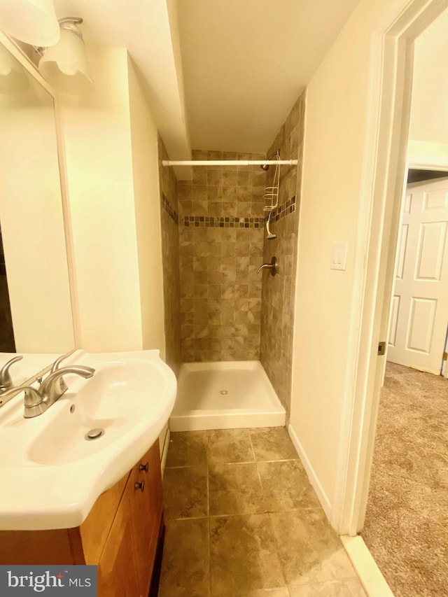 bathroom with vanity, tiled shower, and tile patterned floors