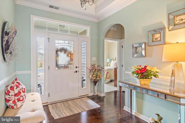 foyer entrance with dark hardwood / wood-style flooring and ornamental molding