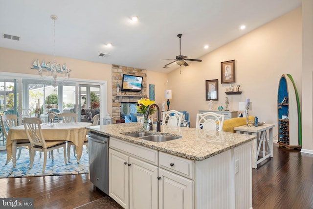 kitchen featuring lofted ceiling, a kitchen island with sink, hanging light fixtures, sink, and dark hardwood / wood-style floors