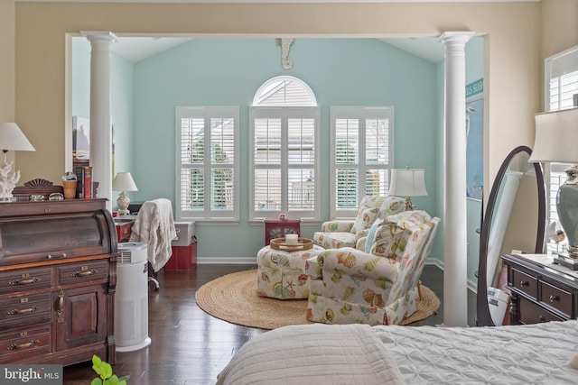 bedroom featuring lofted ceiling, dark hardwood / wood-style flooring, and ornate columns