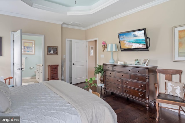 bedroom with a raised ceiling, dark wood-type flooring, ensuite bath, and ornamental molding