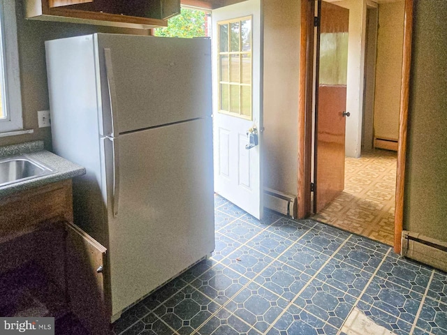 kitchen with a baseboard radiator and white refrigerator