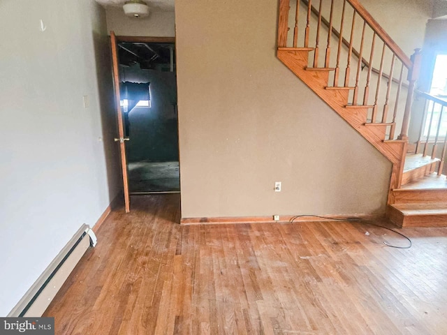 stairway with hardwood / wood-style flooring and baseboard heating