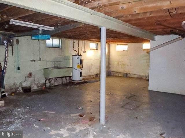 basement featuring electric water heater and sink